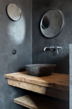 a bathroom sink sitting on top of a wooden counter next to a wall mounted mirror