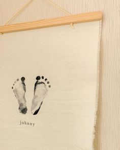 a white wall hanging with two footprints on it