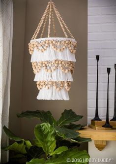 a chandelier hanging from the ceiling next to a potted plant