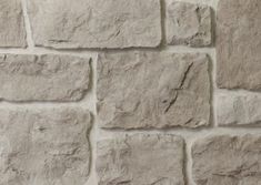 a stone wall that is made out of grey bricks