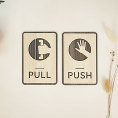 two wooden signs with the words pull and push on them next to some dried flowers