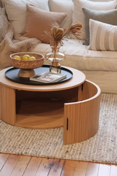 a living room with a couch, coffee table and pillows on the carpeted floor