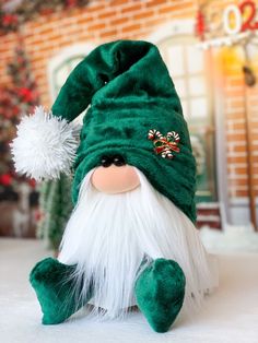 a green and white gnome stuffed animal sitting on top of a table