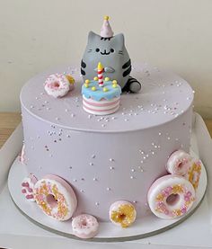 a birthday cake with donuts and a cat on top