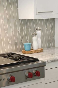 a stove top oven sitting inside of a kitchen next to a white cupboards and counter