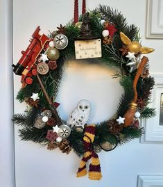 a christmas wreath with an owl and other decorations hanging from it's front door