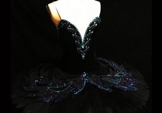 a black dress with blue sequins on the bust and bottom, sitting on a mannequin