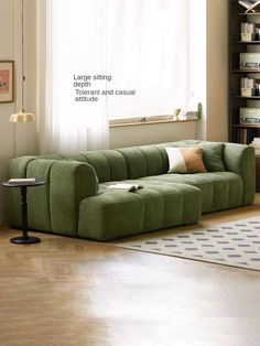 a green couch sitting in front of a window