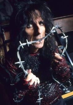 an image of a woman with barbed wire around her mouth and hands in front of her face