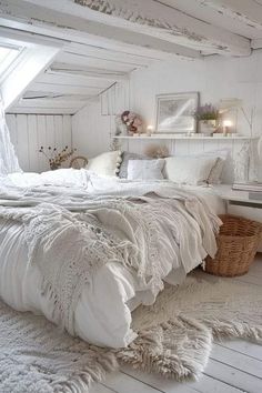 a bedroom with white bedding and pillows in the corner, next to a window