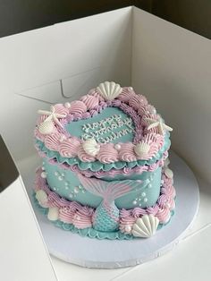 a birthday cake in the shape of a heart with seashells and shells on it