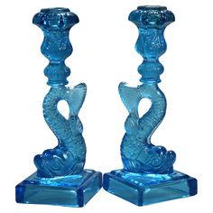 two blue glass candlesticks sitting next to each other