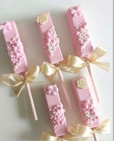 pink and gold candy sticks with bows on them