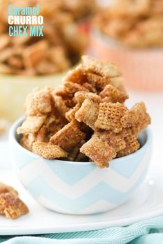 cereal chex mix in a blue and white bowl on a plate with other snacks