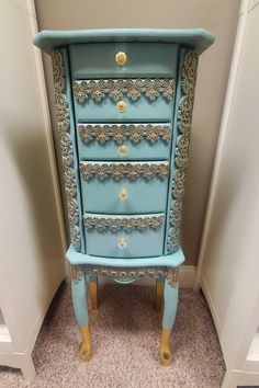 a blue dresser with gold trim and drawers