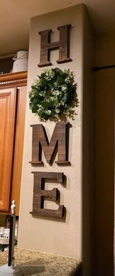 the word home is made out of wood letters and plants on it's wall