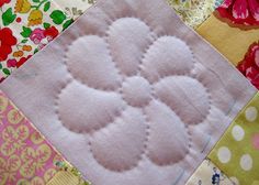 a close up of a patchwork quilt with flowers on it