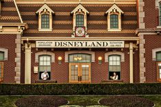 the front entrance to disneyland's main building with people looking out from the windows