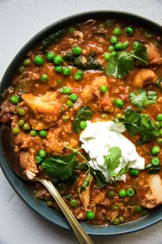 a bowl filled with meat, peas and sour cream