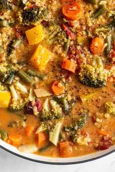 a bowl filled with soup and vegetables on top of a table