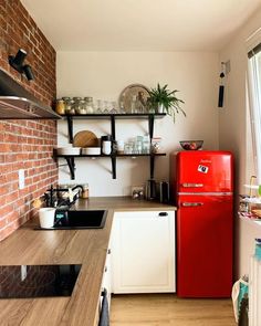 a red refrigerator freezer sitting inside of a kitchen