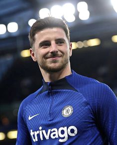 a close up of a soccer player wearing a blue uniform and smiling at the camera