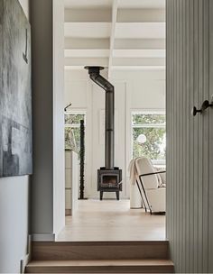 a living room with stairs leading up to a wood burning stove in the middle of it