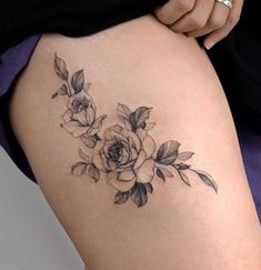 a woman's thigh with a rose tattoo on the lower half of her leg