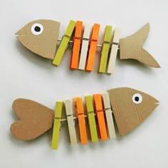 two fish made out of clothes pegs sitting next to each other