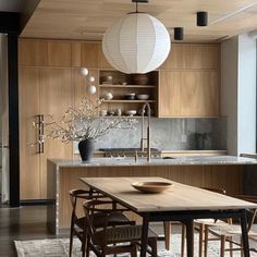 a dining room table and chairs in front of a kitchen with an island countertop