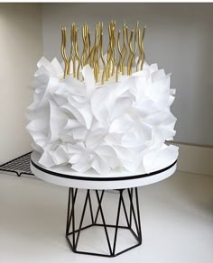 a cake with gold forks on top of it sitting on a white table in a room