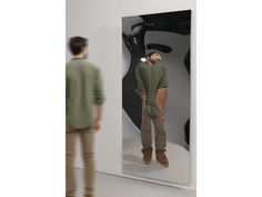 a man standing in front of an apple mirror