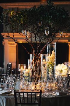 a table is set up with candles and centerpieces for an elegant wedding reception