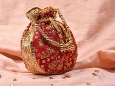 Red Potli Bag with Pearl Handle Strap An ideal for brides rocking the classic red bridal lehenga on their wedding with its classy zari work and a pearl handle strap all in gold the Dulhan Potli Bag is ready to beautify you. Fabric Raw Silk Color Red Embroidery Zari Work in Gold Size amp Dimensions Height - 8 inWidth - 7.5 inDepth - 1.5 in Strap Pearl Handle Strap Closure Tasseled Drawstring Compartments Single compartment Care Wipe with a soft clean amp dry cloth to remove dust When not in use s Red Bag With Zari Work For Festivals, Red Handwork Potli Bag For Party, Gold Embroidered Potli Bag For Gift, Red Bags With Zari Work For Diwali, Traditional Red Party Bag, Red Festive Bag For Festivals, Red Zari Work Potli Bag For Party, Festive Red Zari Work Potli Bag, Gold Handwork Potli Bag