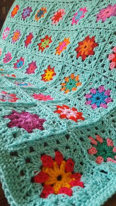 a crocheted blanket with flowers on it