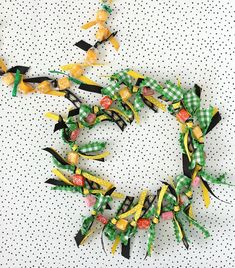 a green and yellow ribbon wreath on a white polka dot tablecloth with black dots