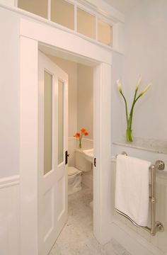 an open door leading to a white bathroom