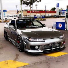 a silver sports car parked at a gas station