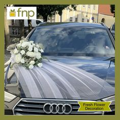 a wedding car with flowers on the hood