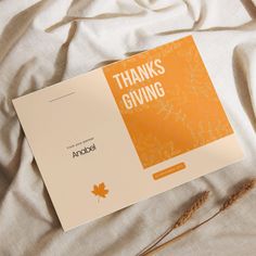 an orange and white thank card sitting on top of a bed with the words thanks giving