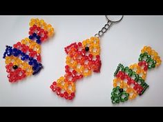 two different colored beads are hanging from a key chain on a white surface, with one beaded and the other made out of plastic beads