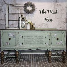 an old dresser with writing on it in front of a sign that says the mad hen