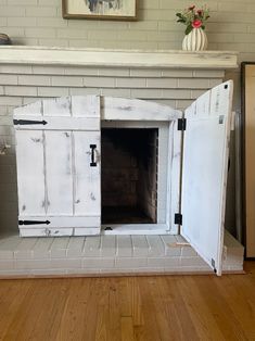 an old fireplace has been painted white and is being used as a storage unit for the fire place