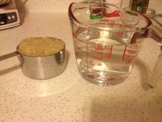 a measuring cup filled with liquid next to an empty measuring cup on a counter top