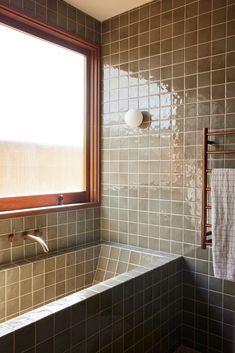 a bath tub sitting next to a window in a bathroom