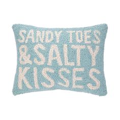 a blue pillow that says sandy toes and salty kisses on the front with white lettering