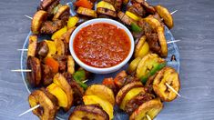 skewered meats and vegetables with ketchup on a blue platter