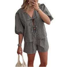 a woman is taking a selfie with her cell phone while wearing a black and white checkered romper