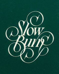 the words slow burn are written in cursive type on a dark green background