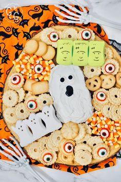 a platter filled with cookies, candy and treats to look like ghost faces for halloween